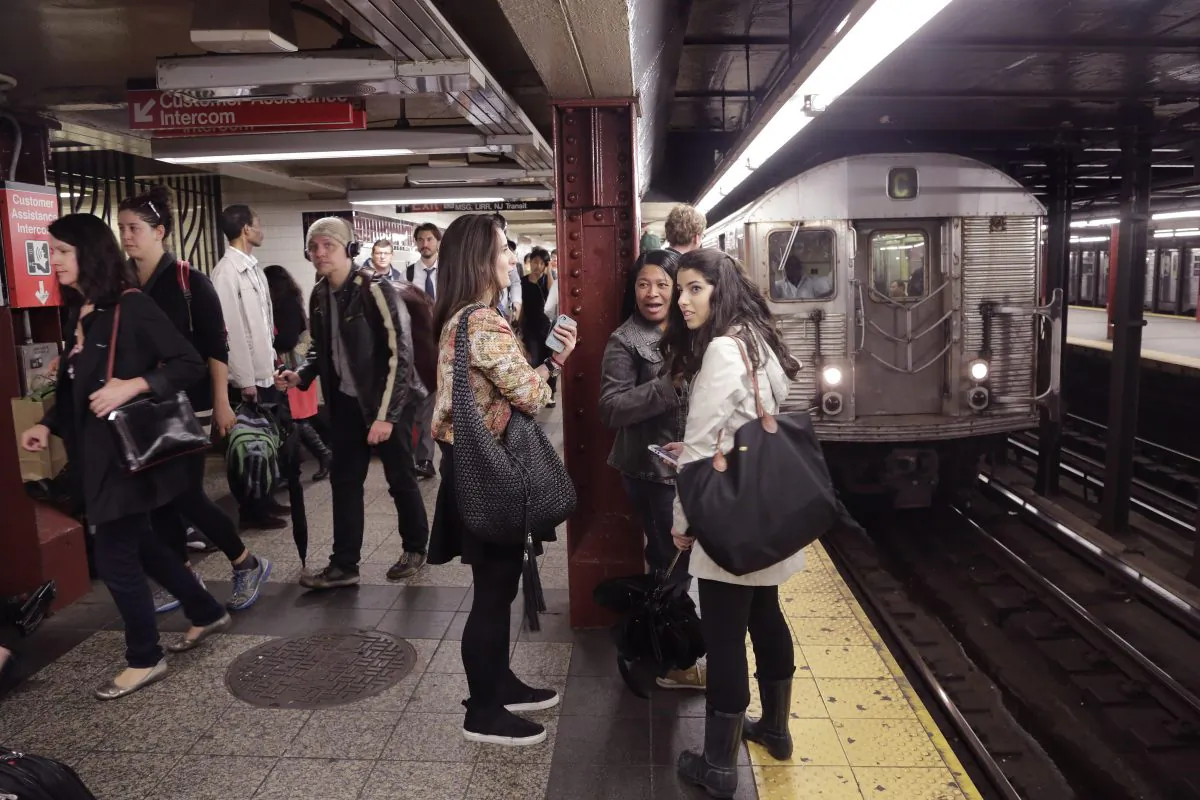 Subway passengers wait on a platform, Thursday, Sept. 25, 2014 in New York. (AP Photo/Mark Lennihan)