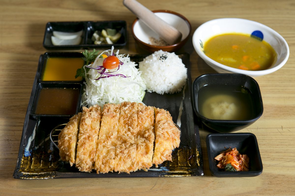 Tonkatsu, or pork cutlet, served with rice and curry. Diners can grind sesame seeds in a mortar and pestle to add to the tonkatsu sauce. (Samira Bouaou/Epoch Times)