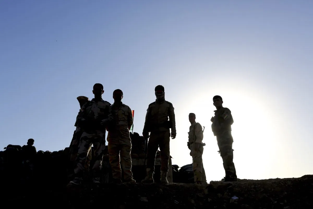Kurdish Peshmerga fighters stand guard with their weapons as they patrol the front line with the Islamic State group in Kirkuk, 290 kilometers (180 miles) north of Baghdad, Iraq, Saturday, Sept. 27, 2014. The tense standoff frustrates many of the young soldiers, away from their families now for several months, even as other units make gains with the help of U.S. and French airstrikes. (AP Photo/Hadi Mizban)