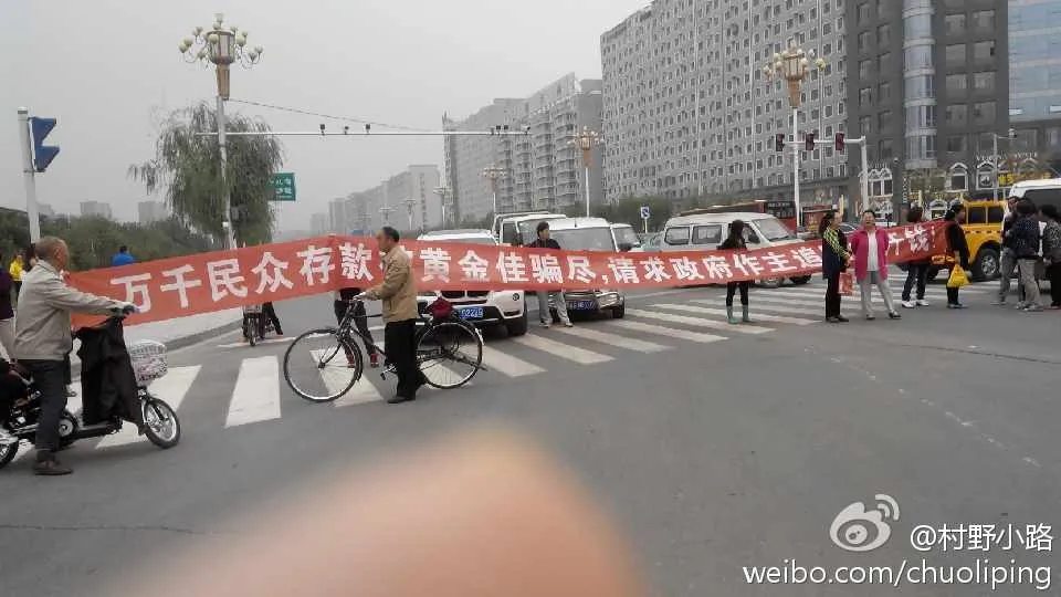 Protesters hold a banner reading “Huang Jin Jia Lied to Thousands. We Demand the Government Get Our Money Back,” stretched across a road in Zhangjiakou City, Hebei Province, on Sept. 22. (Weibo.com)