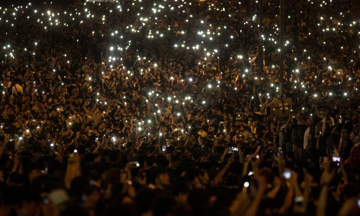 Protesters wave their cell phones in the air in the streets outside the Hong Kong Government Complex on September 29, 2014 in Hong Kong. The information of Hong Kong protest has been blocked in mainland China, but many mainland Chinese still made their voice out to support on the internet. (Chris McGrath/Getty Images)
