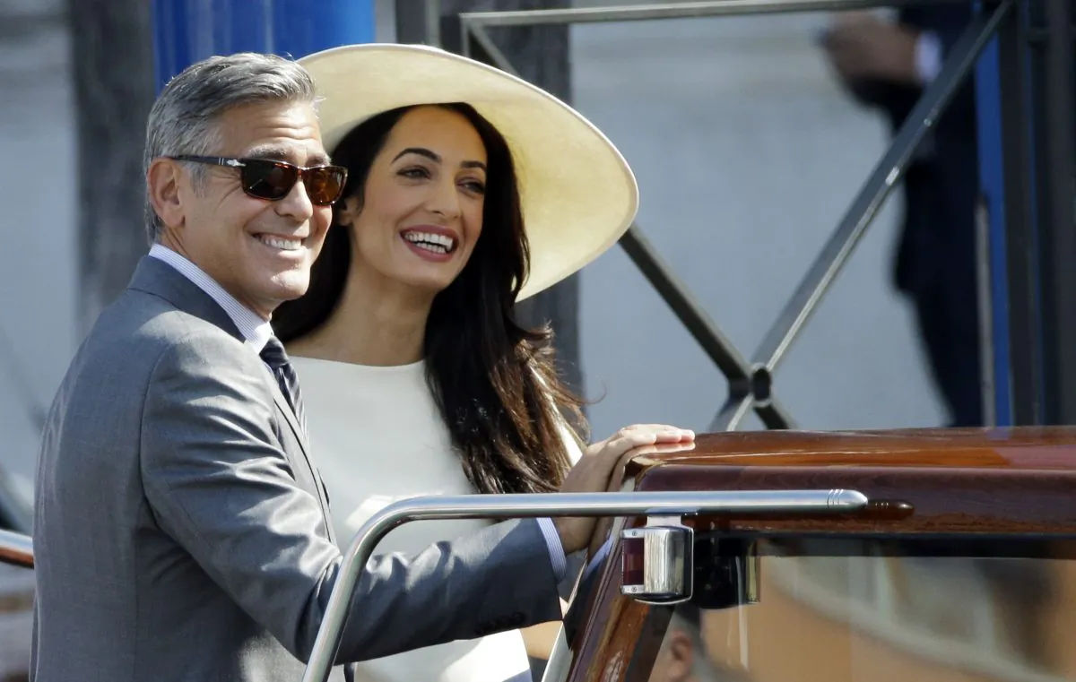 George Clooney and Amal Alamuddin leave Venice's city hall, Italy, Monday, Sept. 29, 2014. Clooney and Amal married Saturday, Sept. 27, the actor's representative said, out of sight of pursuing paparazzi and adoring crowds. (AP Photo/Andrew Medichini)