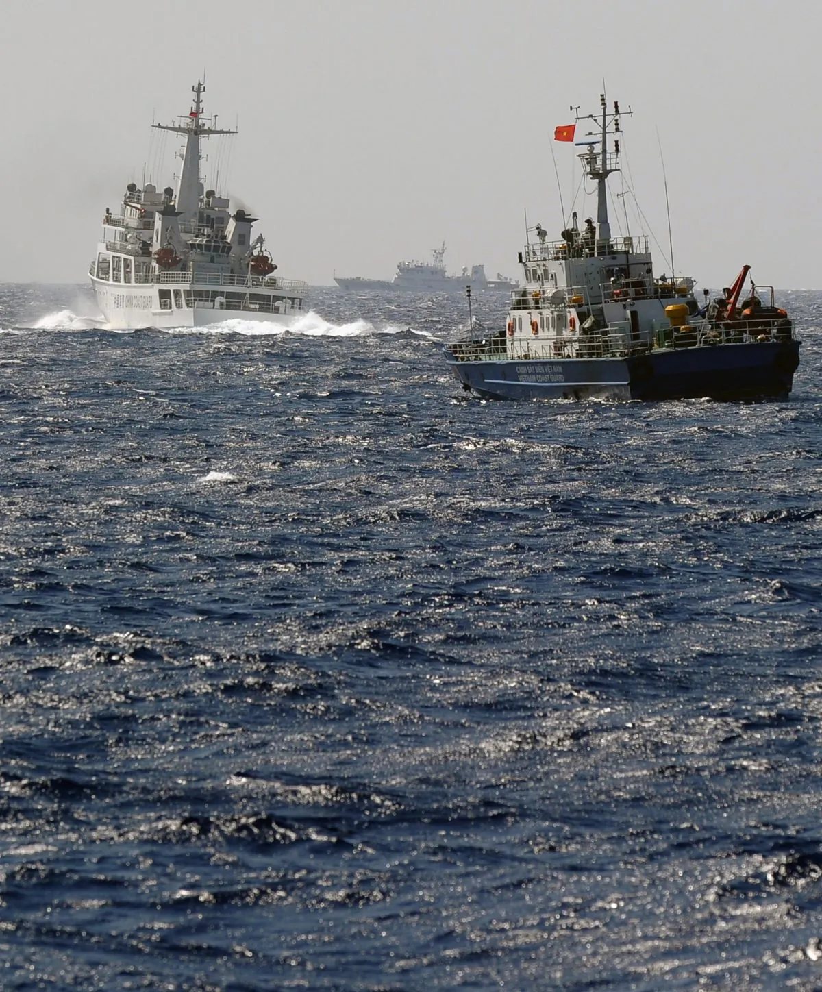 A China Coast Guard ship (L) blocks the way of a Vietnam Coast Guard ship near to the site of a Chinese drilling oil rig (R, background) being installed in the disputed waters in the South China Sea off Vietnam's central coast on May 14, 2014. (Hoang Dinh Nam/AFP/Getty Images)