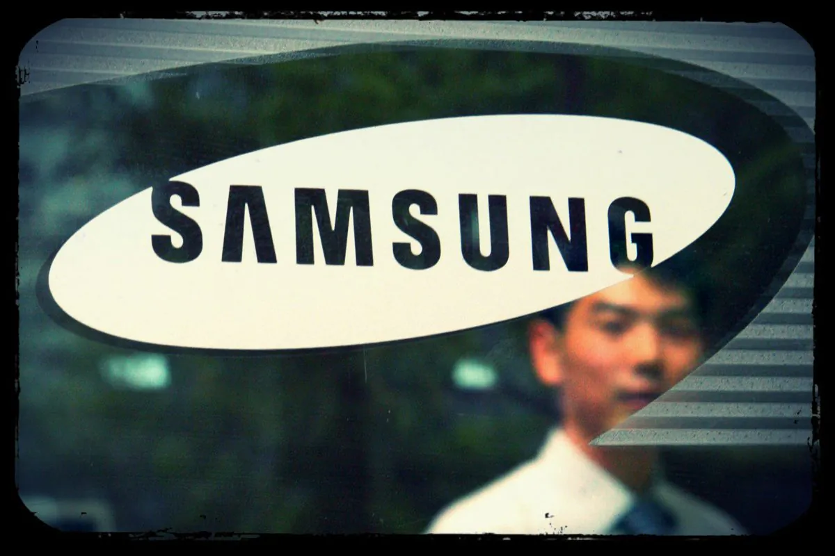 A man walks by a logo of Samsung Group at the group's headquarters in Seoul on April 22, 2008. (Hong Jin Hwan /AFP/Getty Images; effects added by Epoch Times)