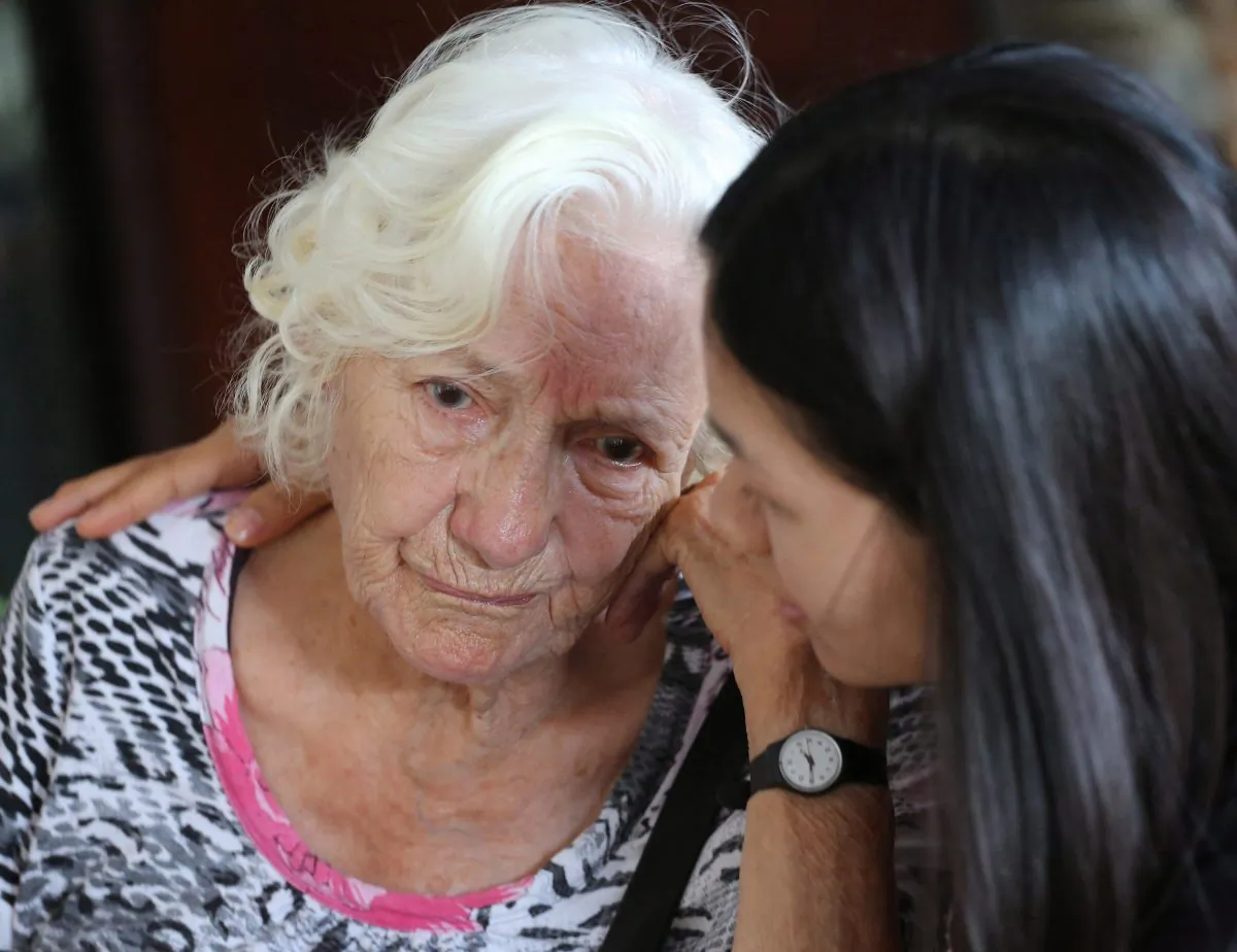 A caregiver comforts a patient suffering from Alzheimer's disease. (Apichart Weerawong/AP Photo)