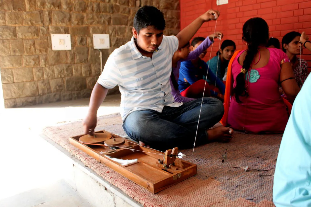 A student works on his charkha at the Gandhi Bhavan Center of Delhi University on Sept. 18, 2014. The course is helping to revive Gandhian value and teach Indian youth how to be self-reliant. (Venus Upadhayaya/Epoch Times)