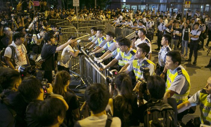 Protesters confront police overnight outside the legislative government complex on October 2, 2014 in Hong Kong. Thousands of pro democracy supporters continue to occupy the streets surrounding Hong Kong's financial district. The protests are a new geopolitical threat affecting financial market sentiment. (Paula Bronstein/Getty Images)
