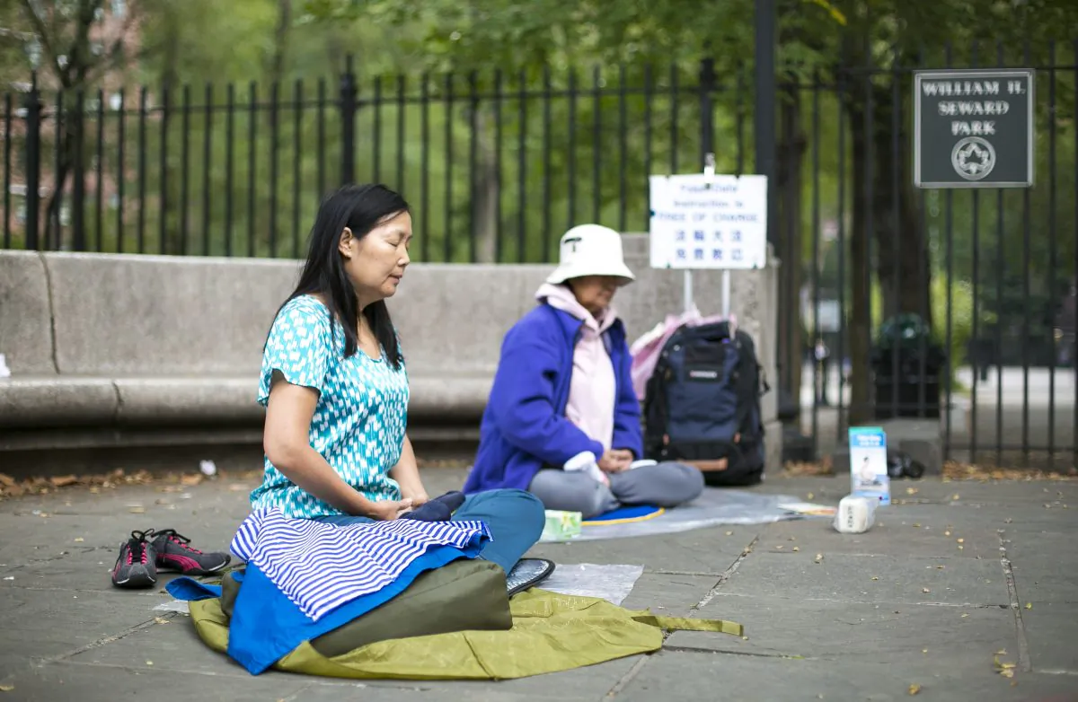 Practitioners of Falun Dafa meditate in the William H. Seward park in Chinatown, Manhattan, on Sept. 29, 2014. (Samira Bouaou/Epoch Times)
