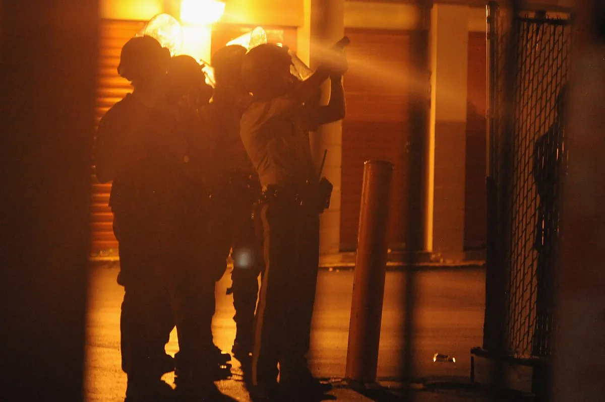 Police officers draw their weapons on a protestor who hid inside a local business on West Florissant Road in Ferguson, Missouri on Aug.17, 2014. Riot police late Sunday hurled tear gas and marched on rioters in the St. Louis suburb of Ferguson, wracked by race riots since police shot dead an unarmed teenager. (Michael B. Thomas/AFP/Getty Images)