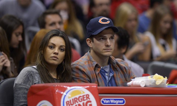 Actors Mila Kunis, left, and Ashton Kutcher watch the Los Angeles Clippers play the Detroit Pistons during the second half of an NBA basketball game, Saturday, March 22, 2014, in Los Angeles. (AP Photo/Mark J. Terrill)
