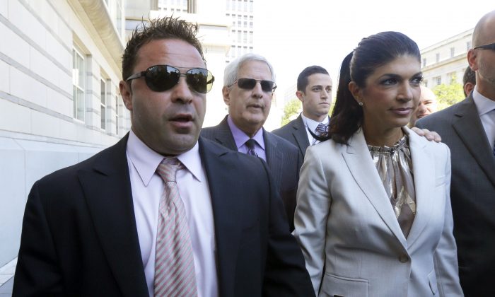 FILE - In this July 30, 2013 file photo, "The Real Housewives of New Jersey" stars Giuseppe "Joe" Giudice, 43, left, and his wife, Teresa Giudice, 41, of Montville Township, N.J., walk out of Martin Luther King, Jr. Courthouse after an appearance in Newark, N.J. Teresa and Giuseppe "Joe" Giudice are scheduled to be sentenced Thursday Oct. 2, 2014 on conspiracy and bankruptcy fraud charges in federal court in Newark.  (AP Photo/Julio Cortez, File)