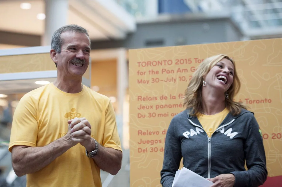 Chris Hadfield and former Olympian Catriona Le May Doan laugh during the announcement of the route for the Toronto 2015 Pan Am Torch Relay at the Eaton Centre in Toronto on Oct. 1, 2014. (The Canadian Press/Hannah Yoon)