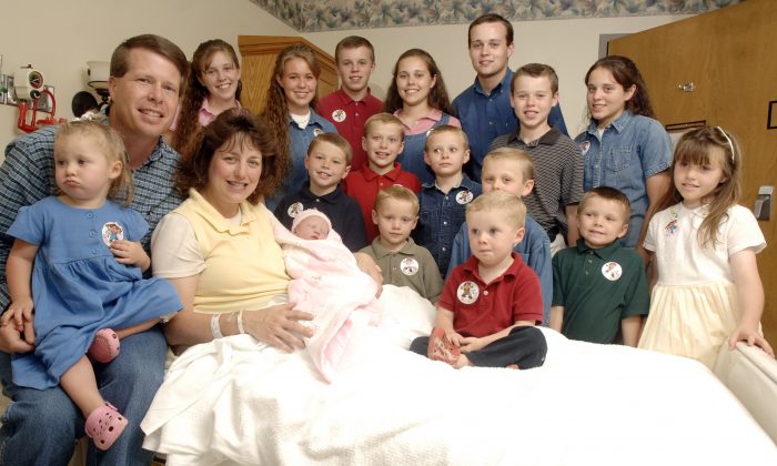 Michelle Duggar, left, is surrounded by her children and husband Jim Bob, third from right after the birth of her 17th child in Rogers, Ark. on Aug. 2, 2007. (Beth Hall/AP Photo)