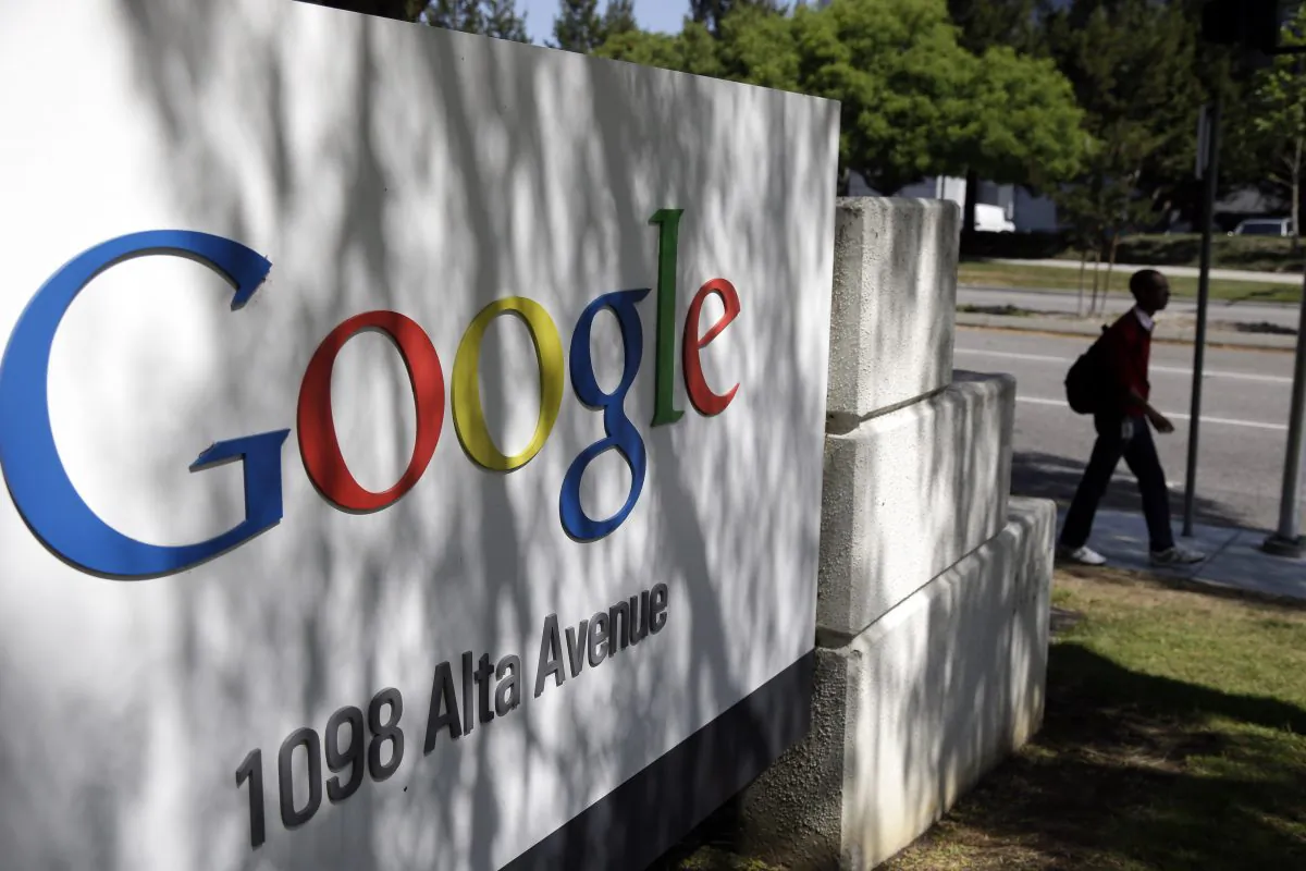 In this June 5, 2014 photo, a man walks past a Google sign at the company's headquarters in Mountain View, Calif. (AP Photo/Marcio Jose Sanchez)