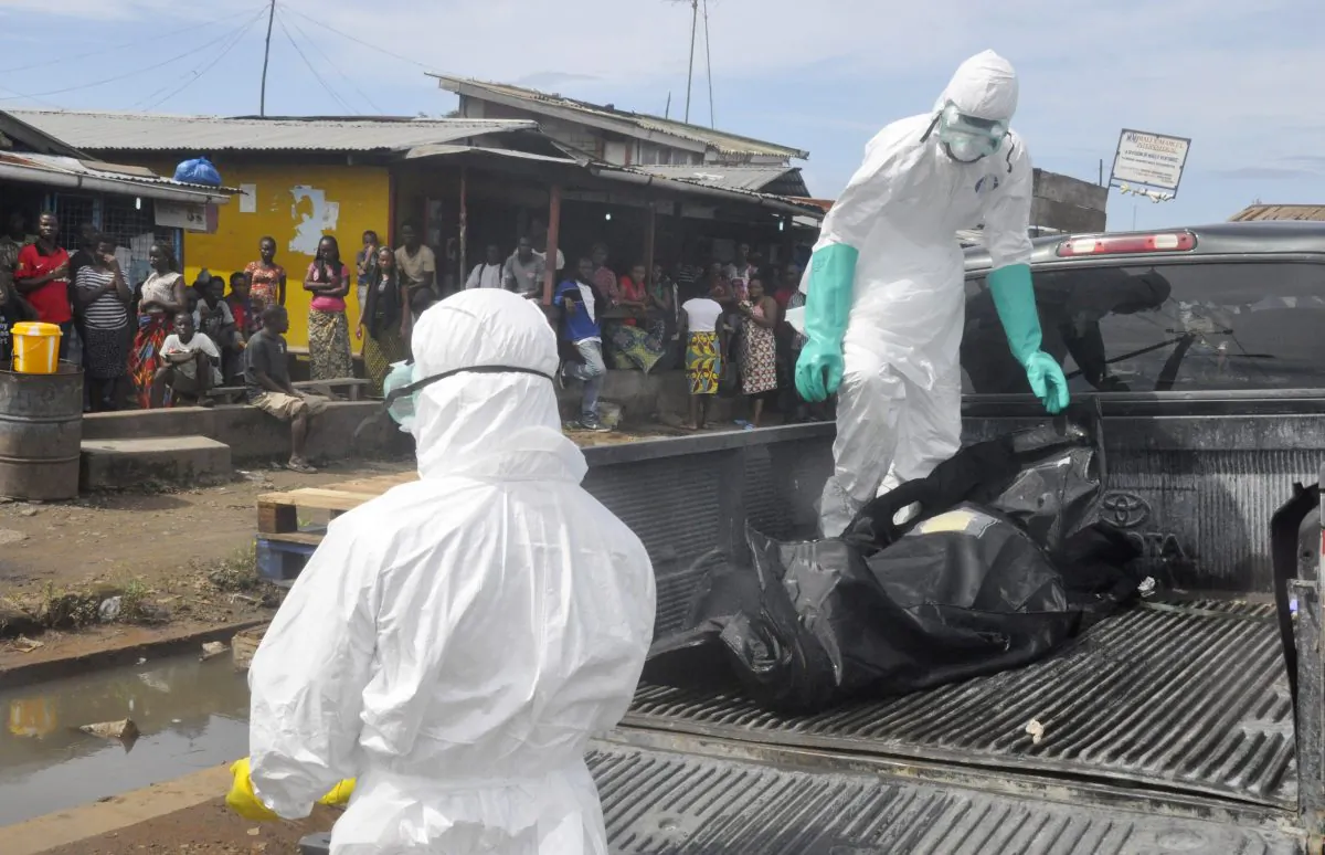 Health workers in protective gear load the body of a woman into a pickup truck in Monrovia, Liberia on Oct. 1 after it was suspected she died from the Ebola virus. The first case of Ebola diagnosed in the U.S. was confirmed in a man who recently traveled from Liberia to Dallas. (AP Photo/Abbas Dulleh)
