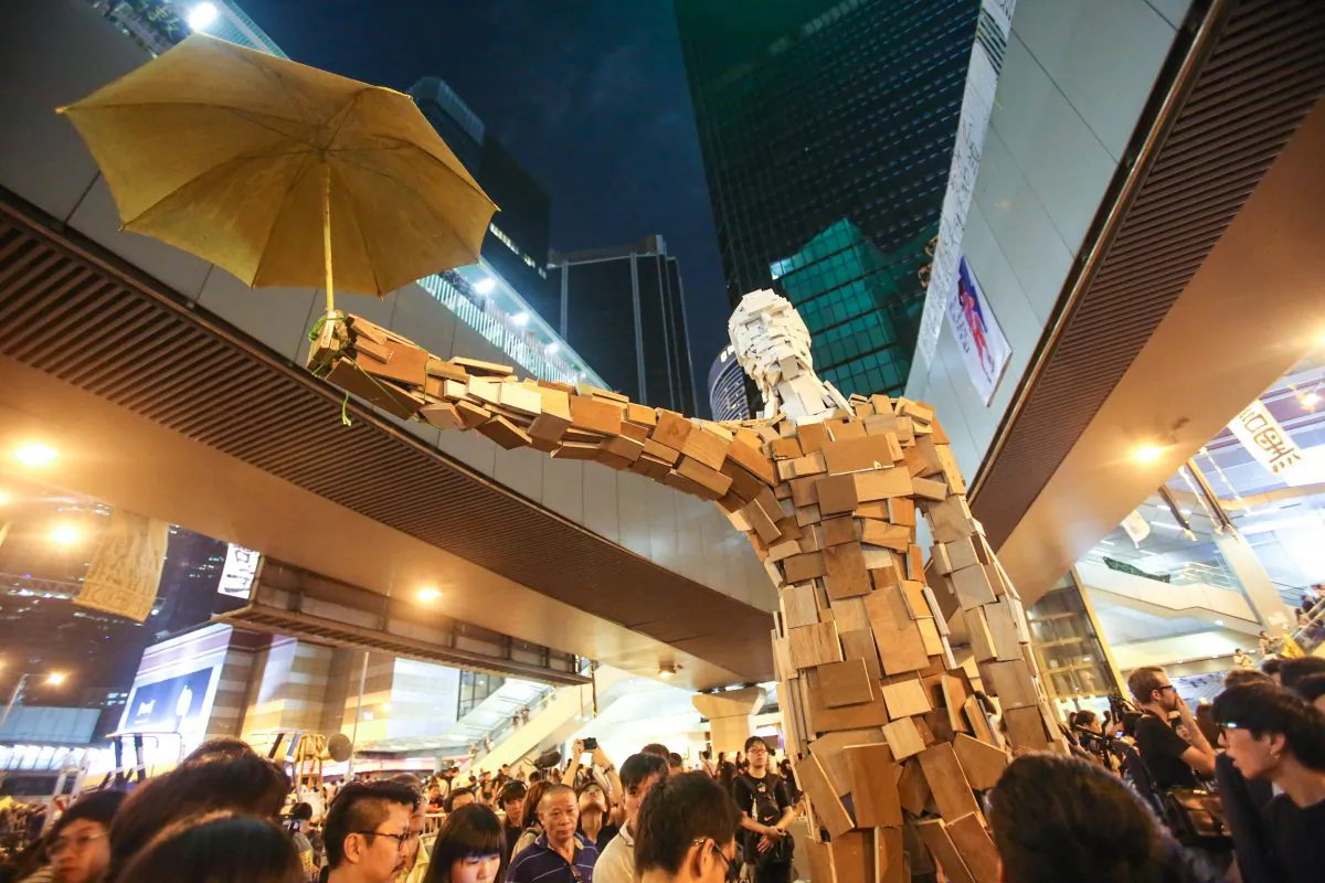 Pro-democracy students set up the statue 'Umbrella Man' created by the Hong Kong artist known as Milk, in the Central District of Hong Kong on Oct. 5, 2014. (Benjamin Chasteen/Epoch Times)