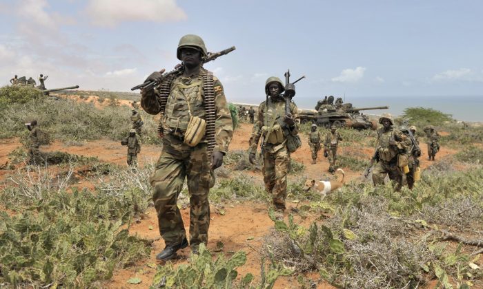 In this photo taken Sunday, Oct. 5, 2014 and provided by the African Union Mission to Somalia (AMISOM), African Union (AU) soldiers march along the top of a hill overlooking the al-Shabab stronghold of Barawe, a coastal town 220 kilometers (135 miles) southwest of Mogadishu, in Somalia. Officials in Somalia say AU and Somali troops have seized Barawe, the last major stronghold held by the Islamic militant group al-Shabab, with the AU claiming it as a significant victory because al-Shabab had used the port to bring in arms and fighters and export charcoal, a multi-million-dollar business. (AP Photo/AMISOM, Tobin Jones)