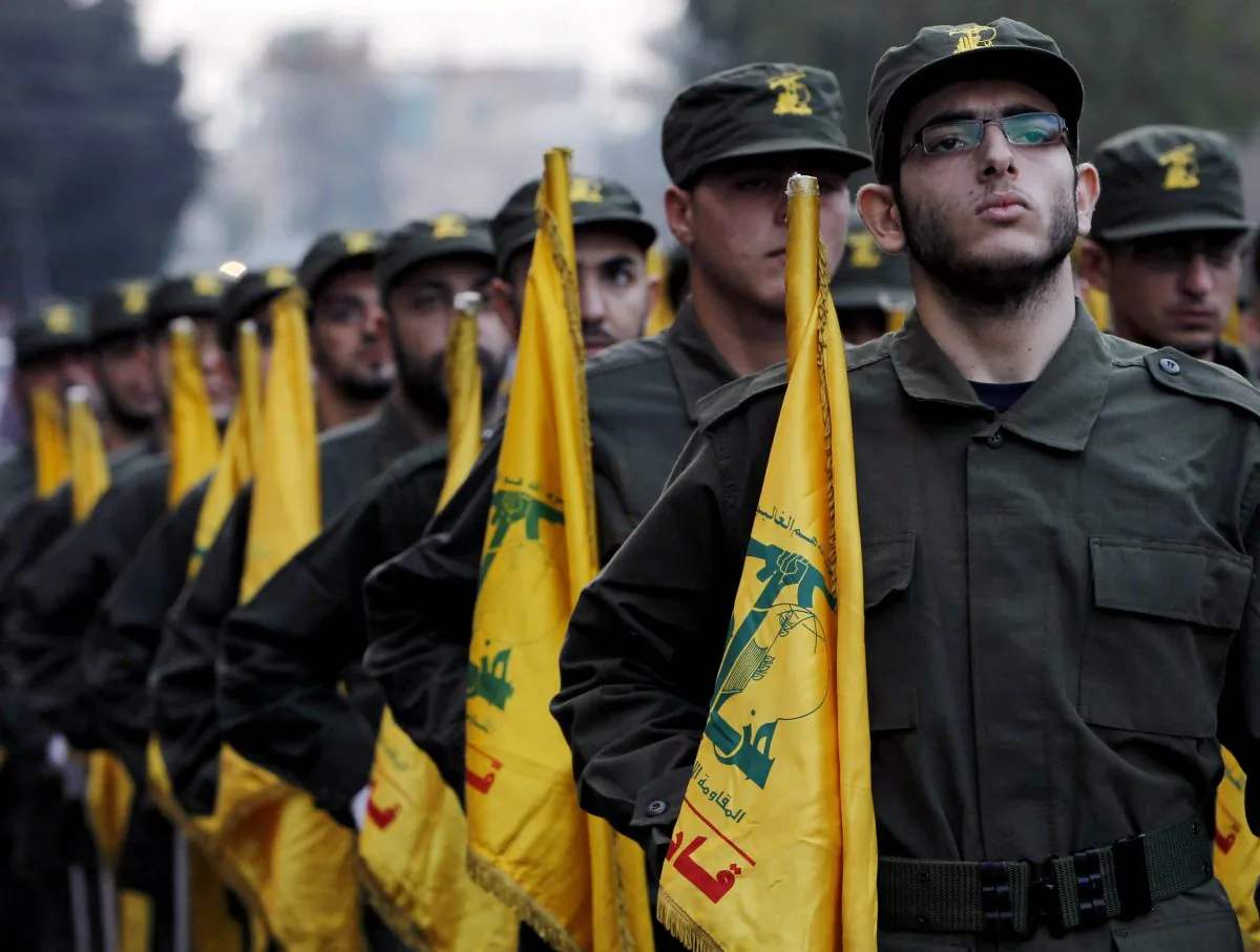 Hezbollah fighters hold their party flags, on Nov. 12, 2010, as they parade during the opening of new cemetery for colleagues who died in fighting against Israel, in a southern suburb of Beirut, Lebanon. (AP Photo/Hussein Malla)