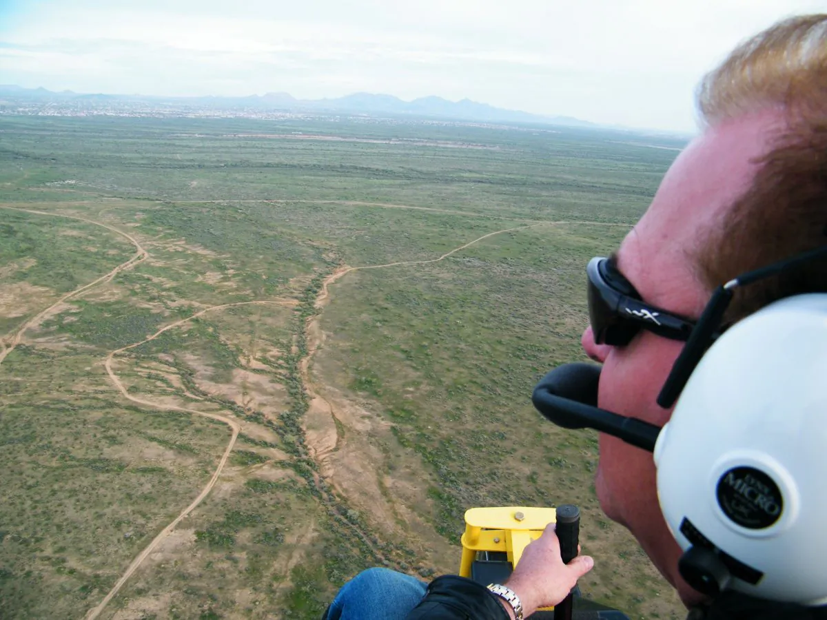 This March 12, 2009 photo provided by Arizona Powerchutes shows instructor Randy Long flying over the Sonoran Desert while powerchuting, in Phoenix, Ariz. Picture a dune buggy with a massive parachute attached to the back of it, sort of a cross between something the Wright Brothers might have designed and that flying machine from the Mad Max movies. Powerchuting provides a flying experience unlike any other. (AP Photo/Arizona Powerchutes)