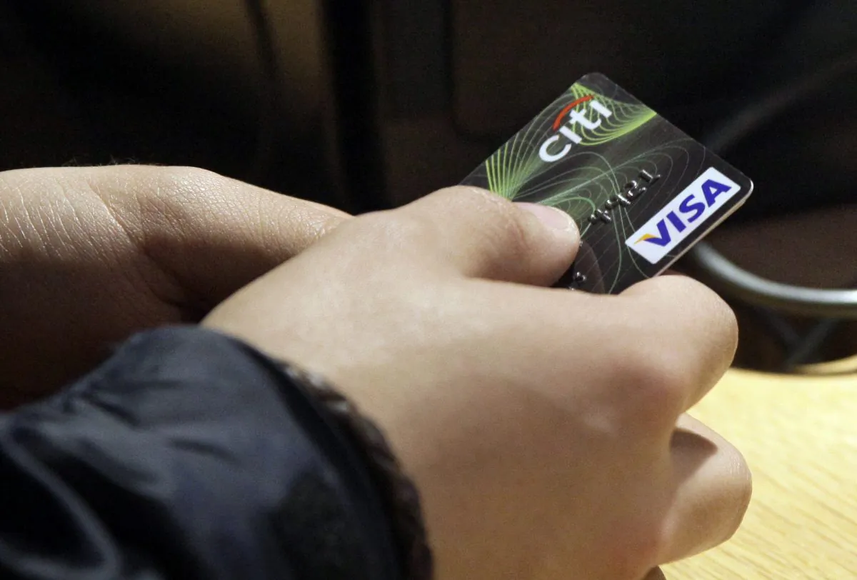 A Visa credit card is offered at the opening of the Superdry store in New York's Times Square, on May 9, 2012. (AP Photo/Richard Drew)