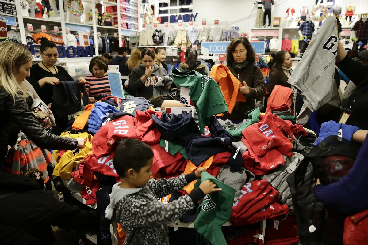People shop at a Gap factory store at the Citadel Outlets in Los Angeles, on Nov. 28, 2013. Americans are expected to spend at the highest rate in three years during what's traditionally the busiest shopping season of the year, the National Retail Federation said Tuesday, Oct. 7, 2014. (AP Photo/Jae C. Hong)