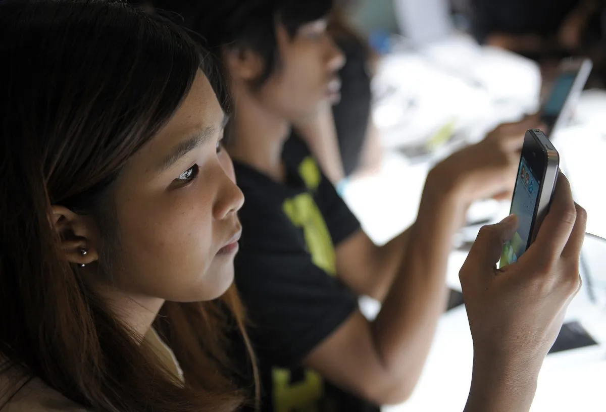 This picture taken on Sept. 29, 2011 shows potential customers trying various models of smartphones at a mobile telecommunication fair in Bangkok. (Christophe Archambault/AFP/Getty Images)