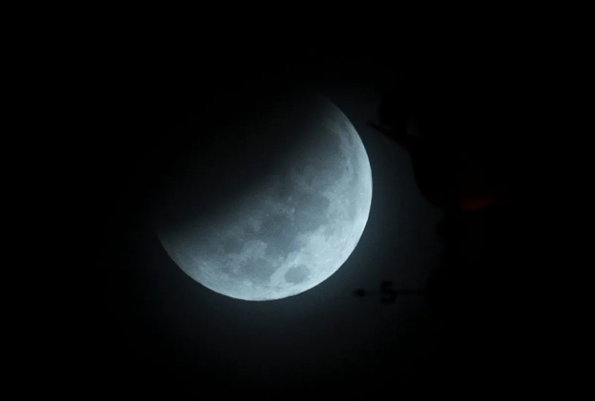 The Earth's shadow begins to fall on the moon during a total lunar eclipse, as seen above Miami, Wednesday, Oct. 8, 2014. (AP Photo/Wilfredo Lee)