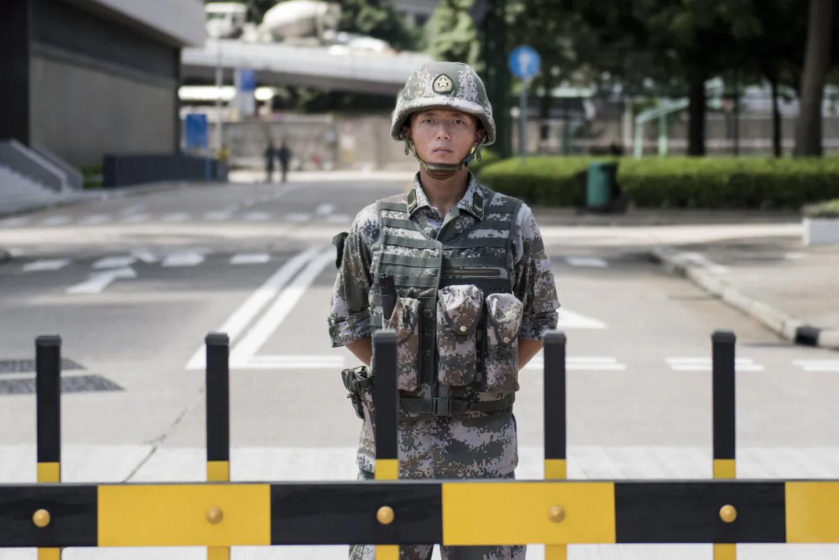 A Chinese People's Liberation Army (PLA) soldier stands guard at the entrance to the PLA's Hong Kong garrison headquarters in Hong Kong on Aug. 29, 2014. Hong Kong's Chengming magazine claims that at a Sept. 15 meeting high-ranking Chinese Communist Party official Zhang Dejiang sketched the conditions under which martial law would be imposed on the restive city of Hong Kong. (Alex Ogle/AFP/Getty Images)