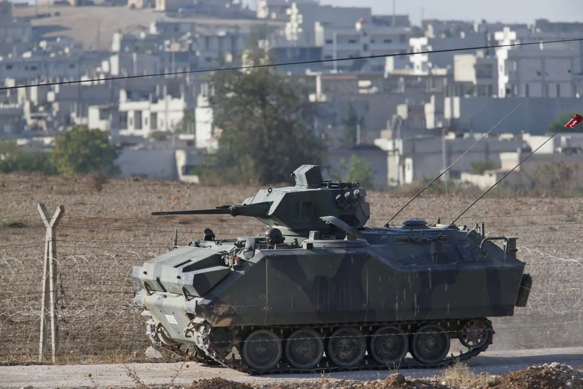 A Turkish forces armoured vehicle patrols the border road in Mursitpinar, on the outskirts of Suruc, on the Turkey-Syria border, as fighting in nearby Kobani, Syria, intensified between Syrian Kurds and the militants of the Islamic State group, Wednesday, Oct. 8, 2014. Kobani has been under the onslaught of the Islamic State group since mid-September when the militants’ launched their offensive in the area, capturing several Kurdish villages around the town and bringing Syria's civil war yet again to Turkey's doorstep.  (AP Photo/Lefteris Pitarakis)