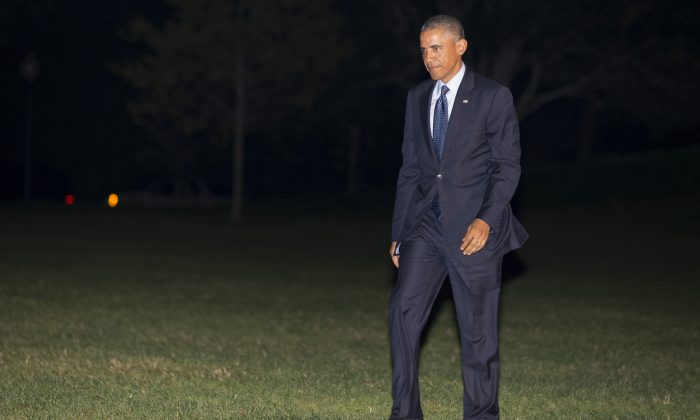 President Barack Obama walks across the South Lawn of the White House on return from a fundraising trip to New York City and Connecticut, Tuesday, Oct. 7, 2014, in Washington. (AP Photo/Jacquelyn Martin)