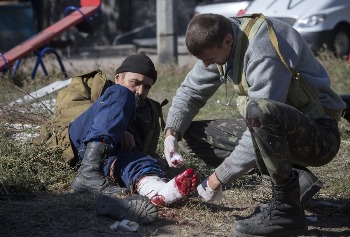 A pro-Russian rebel injured by shrapnel gets a field dressing after action near to the airport in the town of Donetsk, eastern Ukraine Tuesday, Oct. 7, 2014.  Despite a cease-fire declared a month ago between the Ukrainian forces and pro-Russian rebels, the biggest city in eastern Ukraine remains embroiled in fighting . (AP Photo/Dmitry Lovetsky)