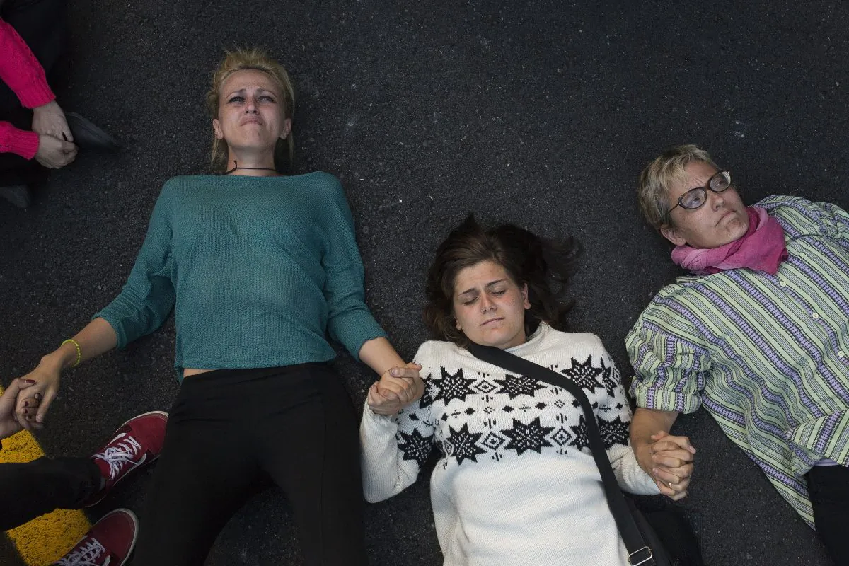 Protestors lie on a street after failing to stop the departure of a vehicle believed to be transporting a dog belonging to a Spanish nurse infected with Ebola in Madrid, Spain, on Oct. 8. The protesters were trying to prevent the from being put down. Canada has announced it is stepping up border checks for Ebola. (AP Photo/Andres Kudacki)