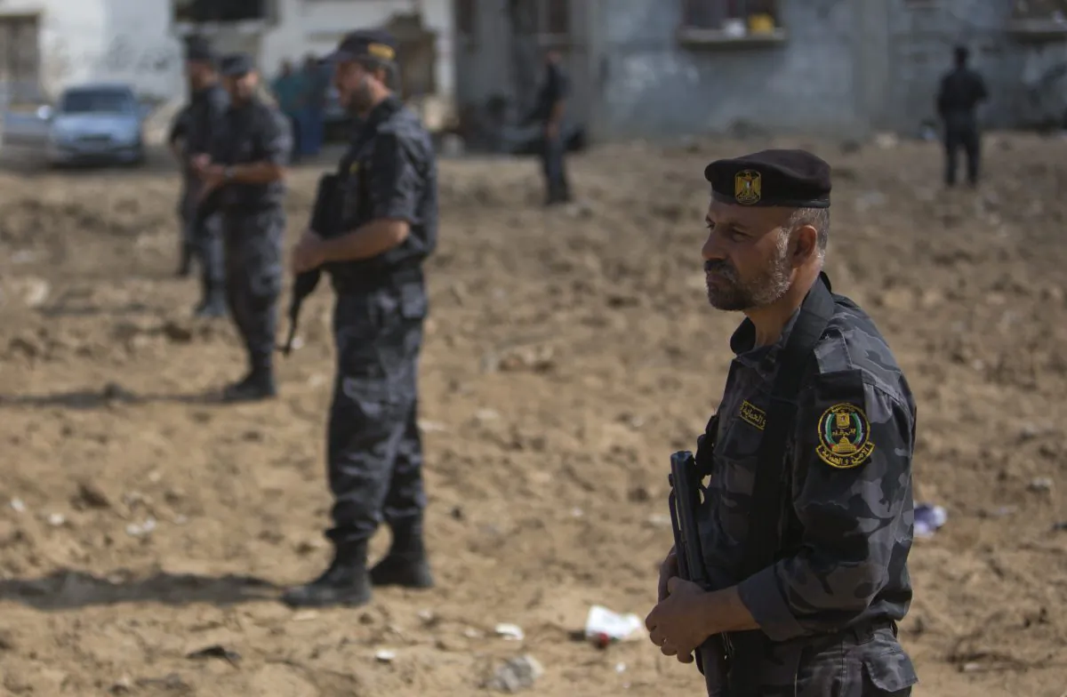 Palestinian Hamas security officers stand guard during the visit of Palestinian Prime Minister Rami Hamdallah to Gaza's neighborhood of Shijaeyih, Thursday, Oct. 9, 2014. Members of the new Palestinian unity government assembled in Gaza on Thursday for their first Cabinet session in the war-battered territory - a largely symbolic meeting meant to mark the end of absolute Hamas control of the coastal strip. (AP Photo/Khalil Hamra)