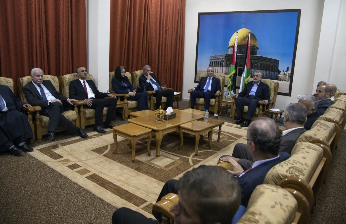 Palestinian Prime Minister Rami Hamdallah and the ministers of the the new Palestinian unity government meet with top Hamas leader in Gaza, Ismail Hamiyeh, in Gaza City, Thursday, Oct. 9, 2014. Members of the new Palestinian unity government assembled in Gaza on Thursday for their first Cabinet session in the war-battered territory,  a largely symbolic meeting meant to mark the end of absolute Hamas control of the coastal strip. (AP Photo/Khalil Hamra)