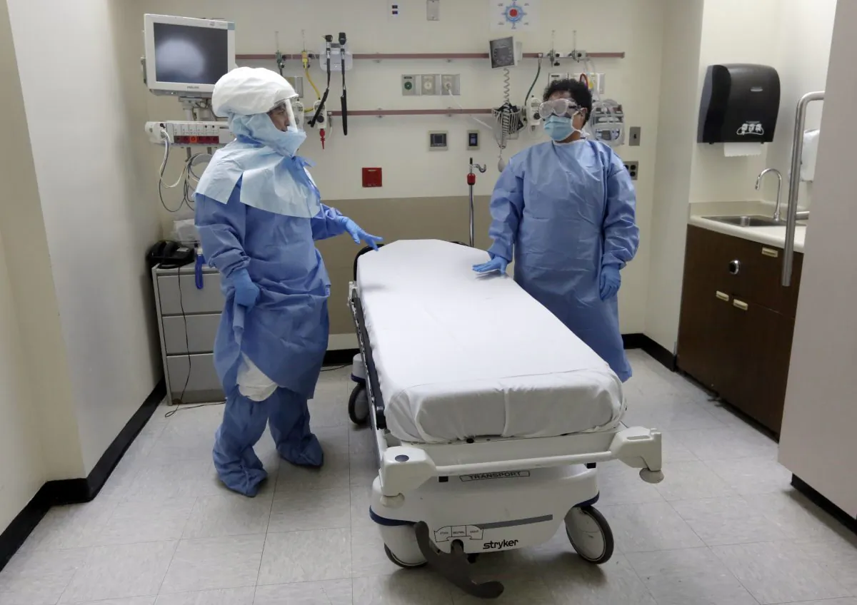 New York City Bellevue Hospital staff poses in protective suits in an isolation room, during a demonstration of procedures for possible Ebola patients, on Wednesday, Oct. 8, 2014. Mayor Bill de Blasio met with city, state, and federal agencies on Thursday to discuss how to prepare for an Ebola outbreak in the city, but the mayor assured New Yorkers that there are no identified cases of Ebola and "no cause for alarm." (AP Photo/Richard Drew)
