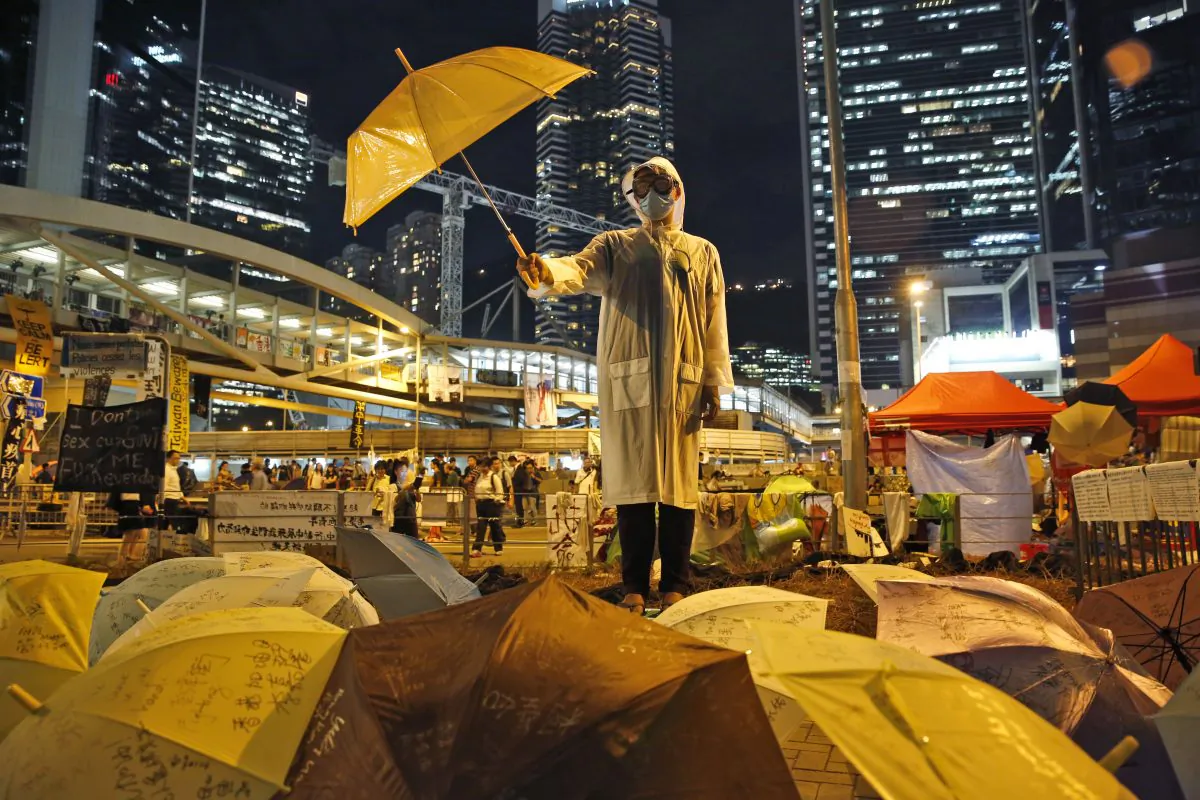 A protester holds an umbrella during a performance on a main road in the occupied areas outside government headquarters in Hong Kong's Admiralty in Hong Kong Thursday, Oct. 9, 2014. (AP Photo/Kin Cheung)