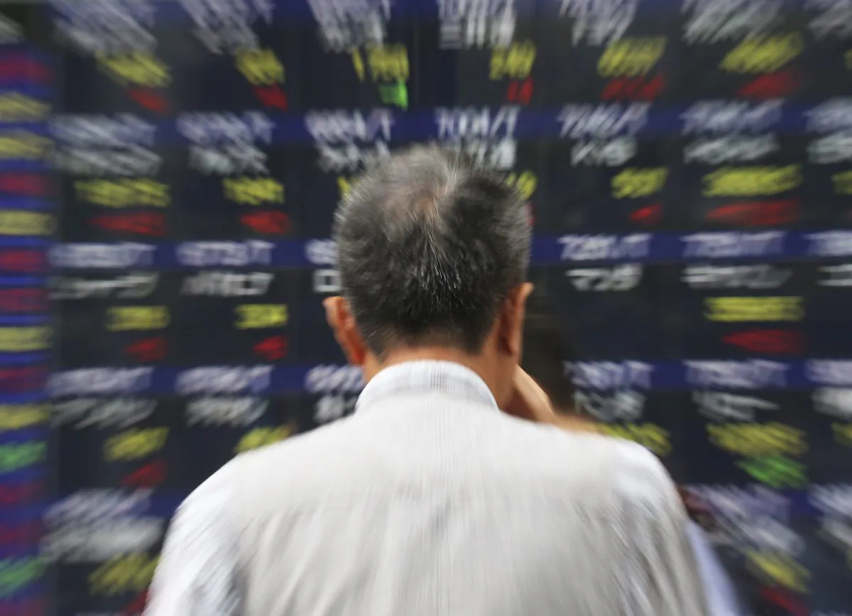 A man watches an electronic stock board of a securities firm in Tokyo, Thursday, Sept. 25, 2014. US stocks were solidly lower in early trading Thursday, Oct. 9, 2014, pruning back some of the gains from a massive rally the day before. Gap shares plunged after the company announced its CEO was retiring. (AP Photo/Mark Lennihan)