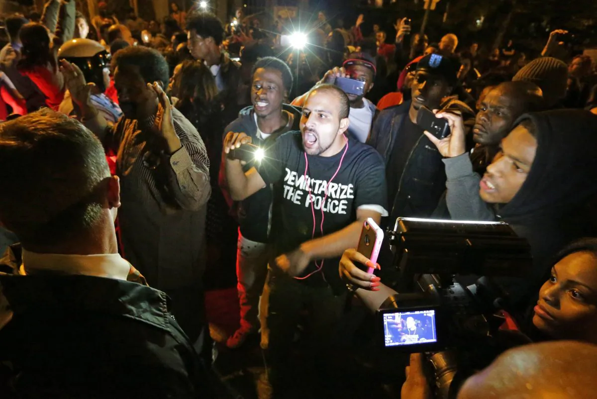 Crowds confront police near the scene where a man was fatally shot by an off-duty St. Louis police officer, in south St. Louis, Oct. 8. (AP Photo/St. Louis Post-Dispatch, David Carson)