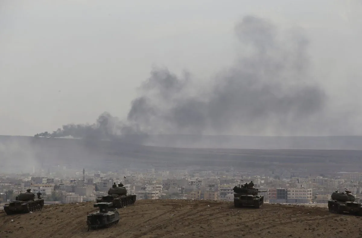 Turkish soldiers in tanks and an armoured vehicle hold their positions on a hilltop in the outskirts of Suruc, Turkey, at the Turkey-Syria border, overlooking smoke rising from a fire caused by a strike in Kobani, Syria, during fighting between Syrian Kurds and the militants of Islamic State group, Thursday, Oct. 9, 2014. Kobani, also known as Ayn Arab, and its surrounding areas, has been under assault by extremists of the Islamic State group since mid-September and is being defended by Kurdish fighters.(AP Photo/Lefteris Pitarakis)