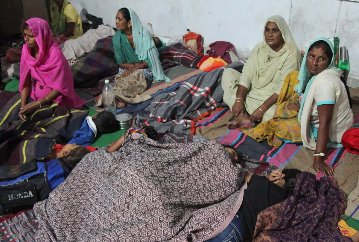 In this Thrusday, Oct. 9, 2014 photo, Indian women take shelter at Abdullian village, in Jammu and Kashmir state, India. A fierce trading of mortar shells and gunfire between India and Pakistan began Sunday night, marking the most serious violation of a 2003 cease-fire accord. (AP Photo/Channi Anand)