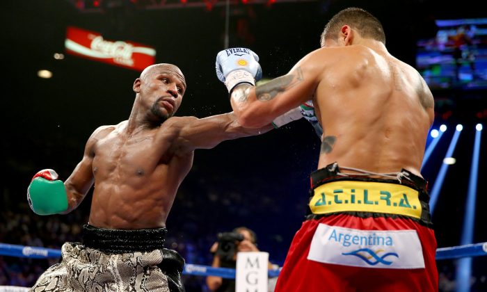 Floyd Mayweather Jr. throws a right to the face of Marcos Maidana during their WBC/WBA welterweight title fight at the MGM Grand Garden Arena on September 13, 2014 in Las Vegas, Nevada.