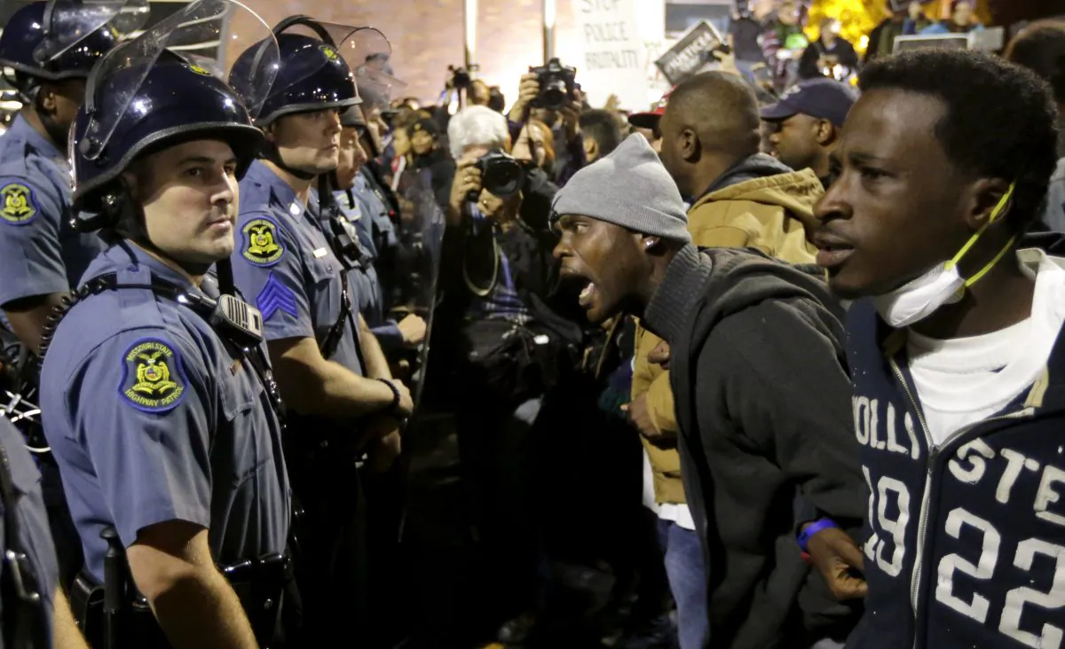 A protester yells at a Missouri State Police officer during a protest at the Ferguson, Mo., police headquarters Friday, Oct. 10, 2014, in Ferguson.  (AP Photo/Charles Rex Arbogast)