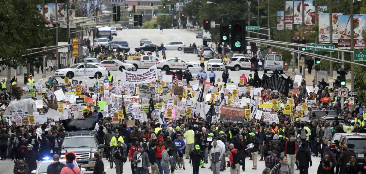 Protesters march down Market Street on Saturday, Oct. 11, 2014, in St Louis. More than 1,000 gathered Saturday in downtown St. Louis for a second day of organized rallies to protest Michael Brown’s death and other fatal police shootings in the area and elsewhere. (AP Photo/Charles Rex Arbogast)