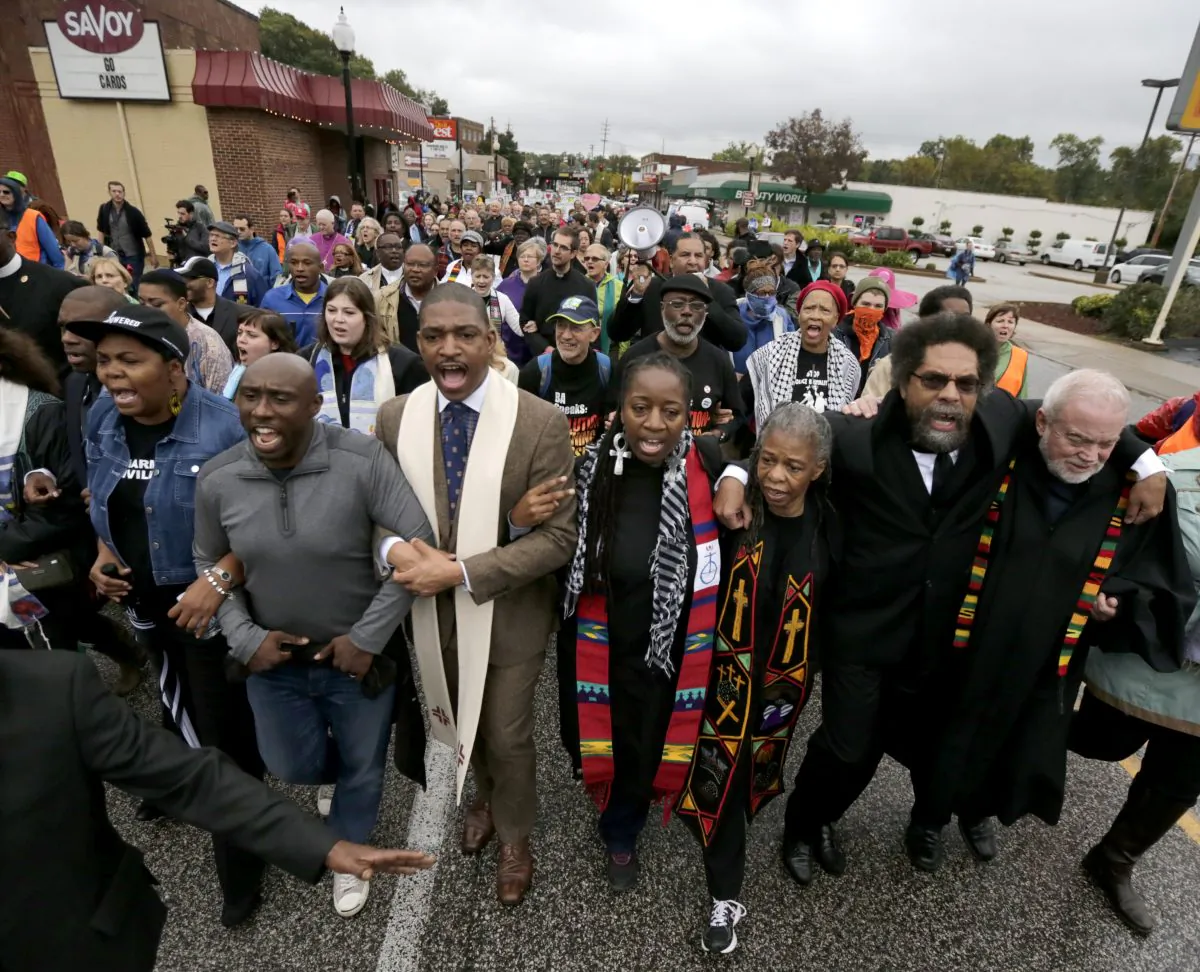 Protesters, including Cornel West, second from right, march to the Ferguson, Mo., police station, Monday, Oct. 13, 2014, in Ferguson. (AP Photo/Charles Rex Arbogast)