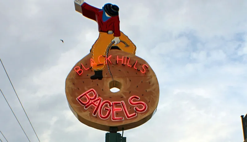 Black Hills Bagels in Rapid City has a unique sign. Where else would you find a cowboy riding a bagel. (Myriam Moran copyright 2014)
