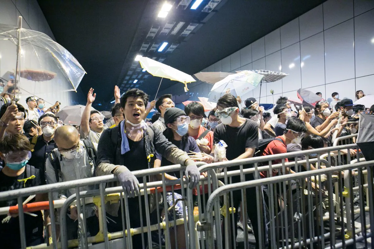 Pro-democracy protesters clash with police after while trying to block off Lung Wo Road, one of the major roadways in Hong Kong, in retaliation after the police removed barriers and opened an occupied road earlier today on Oct. 14, 2014. (Benjamin Chasteen/Epoch Times)