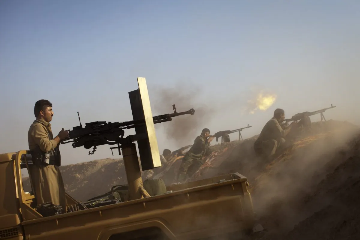 Kurdish Peshmerga fighters fire a Duskha heavy machine gun as they hold a position on the front line in the Gwer district, 40 kilometres south of Arbil, the capital of the Kurdish autonomous region in northern Iraq, on Sept. 15, 2014. (J.M. Lopez/AFP/Getty Images)