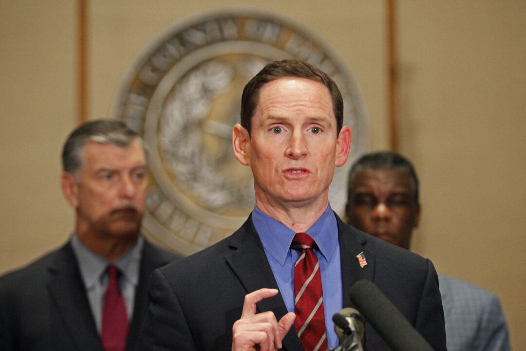 Dallas County Judge Clay Jenkins answers questions at the podium during a press conference held at the Dallas County Commissioners Court concerning the second health care worker to contract Ebola, on Oct. 15, 2014. Standing with Varga (L-R), Dallas Mayor Mike Rawlings and Dallas County Health and Human Services Director Zachary Thompson. (Stewart F. House/Getty Images)