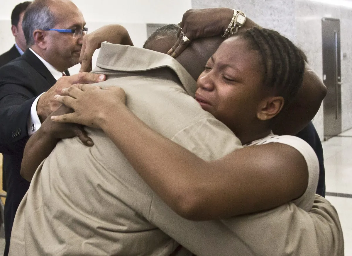 David McCallum, right, hugs family members after his exoneration at Brooklyn's Supreme Court on Wednesday Oct. 15, 2014 in New York.  McCallum and Willie Stuckey, who died in prison, were 16 years old when they were convicted of murder.  A judge exonerated both men for wrongful conviction after nearly 30 years.  (AP Photo/Bebeto Matthews)