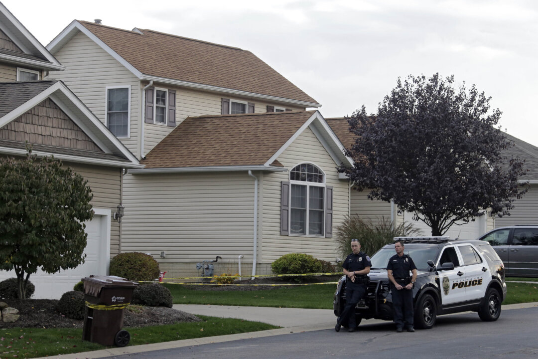 Tallmadge police guard a home in Tallmadge, Ohio Wednesday, Oct. 15, 2014, where Amber Joy Vinson stayed over the weekend before flying home to Dallas. (AP Photo/Mark Duncan)